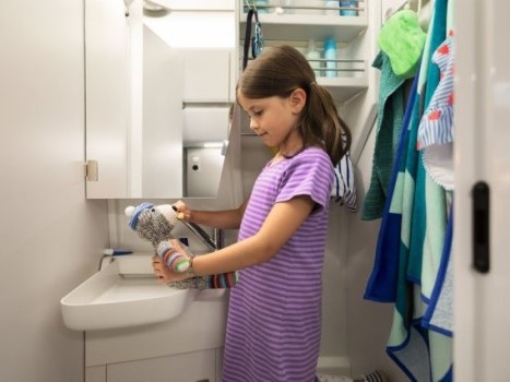 Ein Kind wäscht ihren Teddy in der Nasszelle vom Grand California